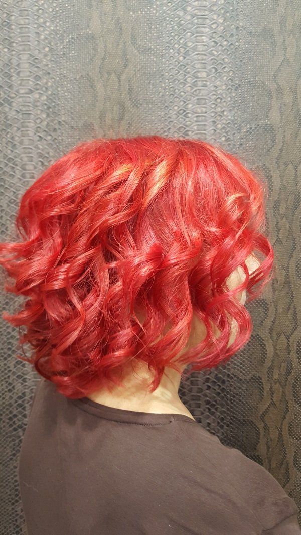 Una mujer con cabello rojo está parada frente a una pared.