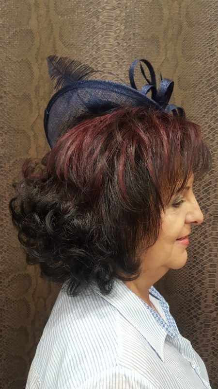 Una mujer que lleva un sombrero azul con una pluma en el pelo.