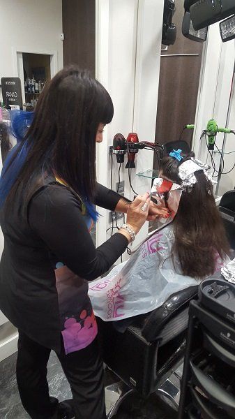 Una mujer se está cortando el pelo en una peluquería.