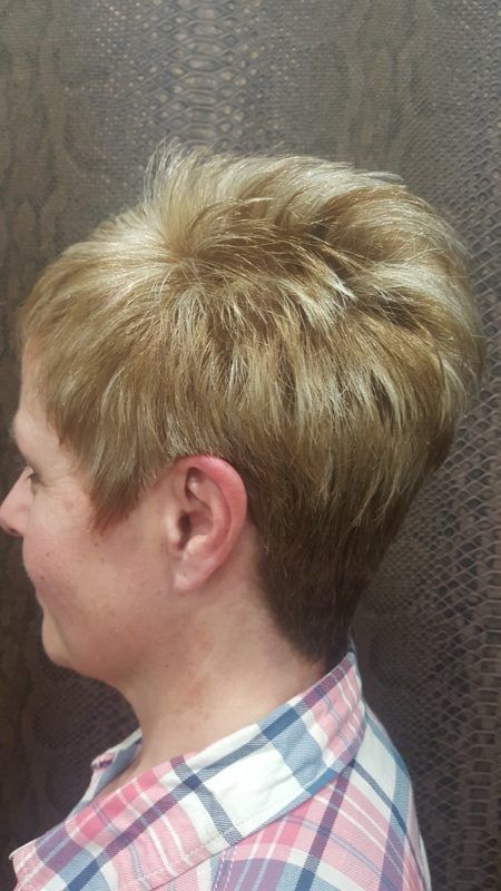 Una mujer con cabello corto y rubio lleva una camisa a cuadros.