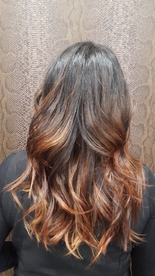 Una mujer con cabello largo y castaño lleva una camisa negra.