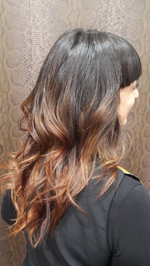 Una mujer con cabello largo está parada frente a una pared.