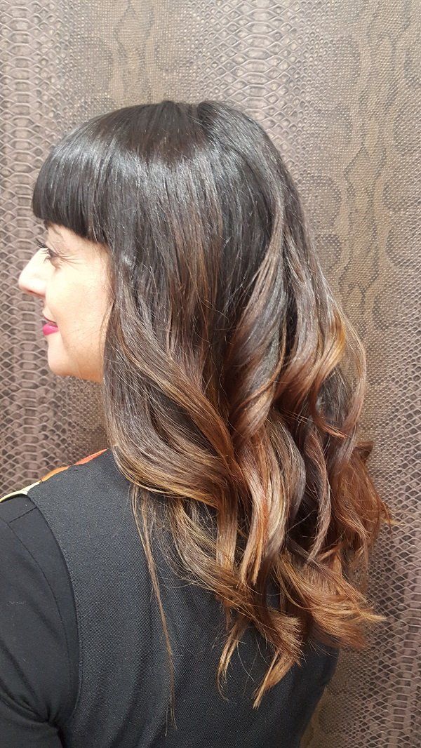 La mujer lleva una camisa negra y tiene el pelo largo.