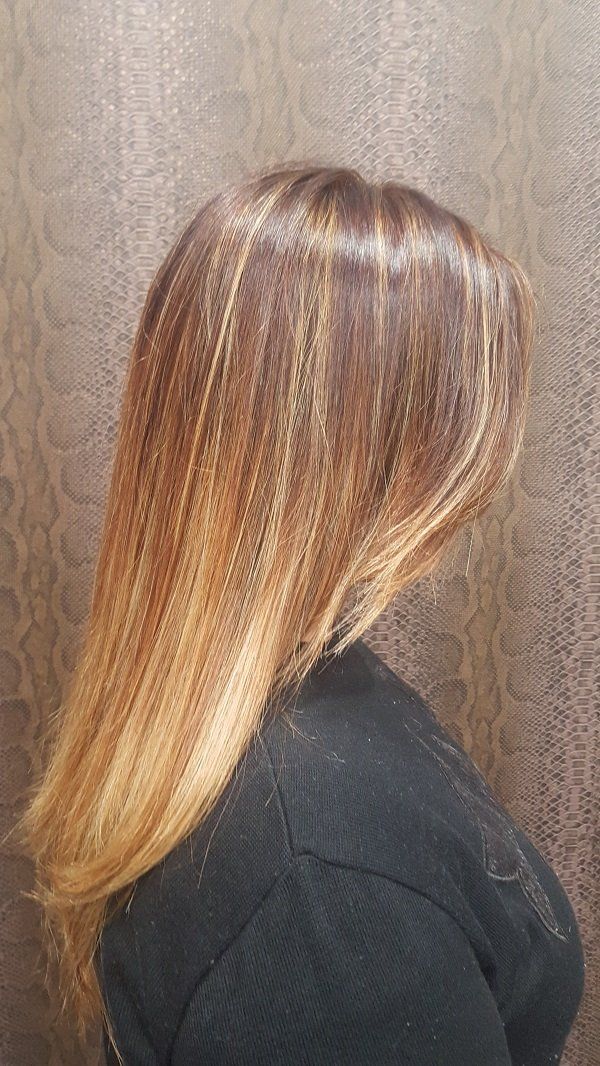 Una mujer con cabello largo y rubio lleva un suéter negro.