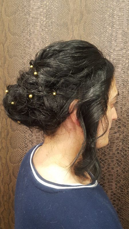 Una mujer lleva el pelo recogido en un moño con cuentas.