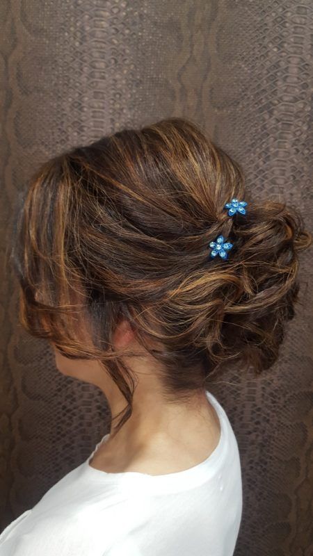 Una mujer lleva el pelo recogido en un moño con pinzas azules.