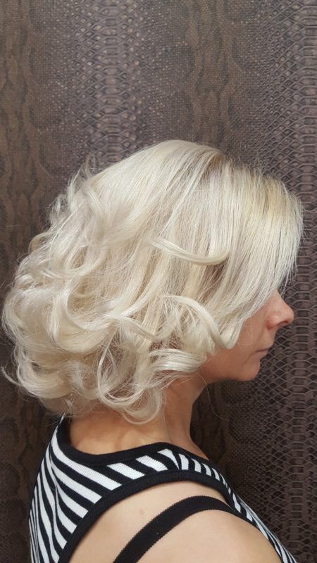 Una mujer con cabello rubio lleva una camisa de rayas blancas y negras.