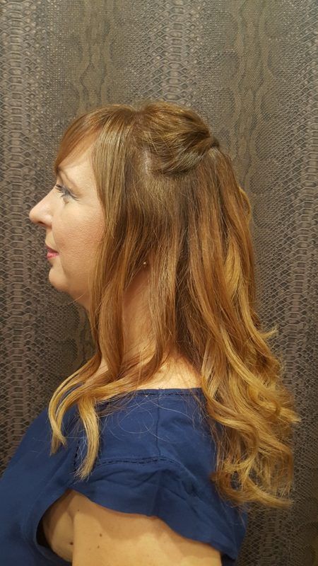 Una mujer con cabello largo y rojo lleva una camisa azul.