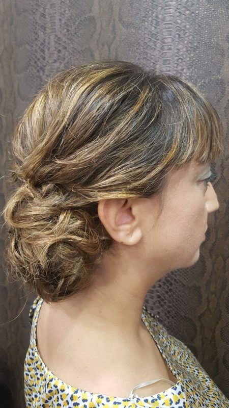 Una mujer con el pelo recogido en un moño lleva una camisa floral.