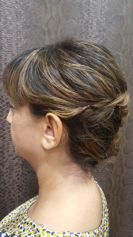 Una mujer lleva el pelo recogido en un moño.