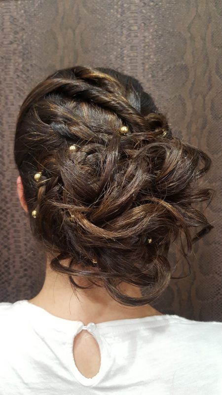 La parte posterior de la cabeza de una mujer con un moño y perlas en el pelo.