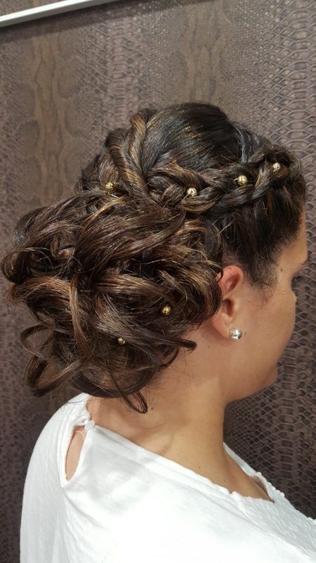 Una mujer lleva una camisa blanca y tiene el pelo recogido en un moño.