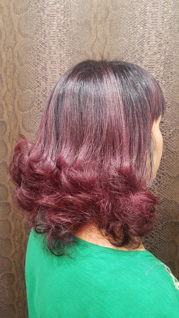 Una mujer con cabello rojo lleva una camisa verde.