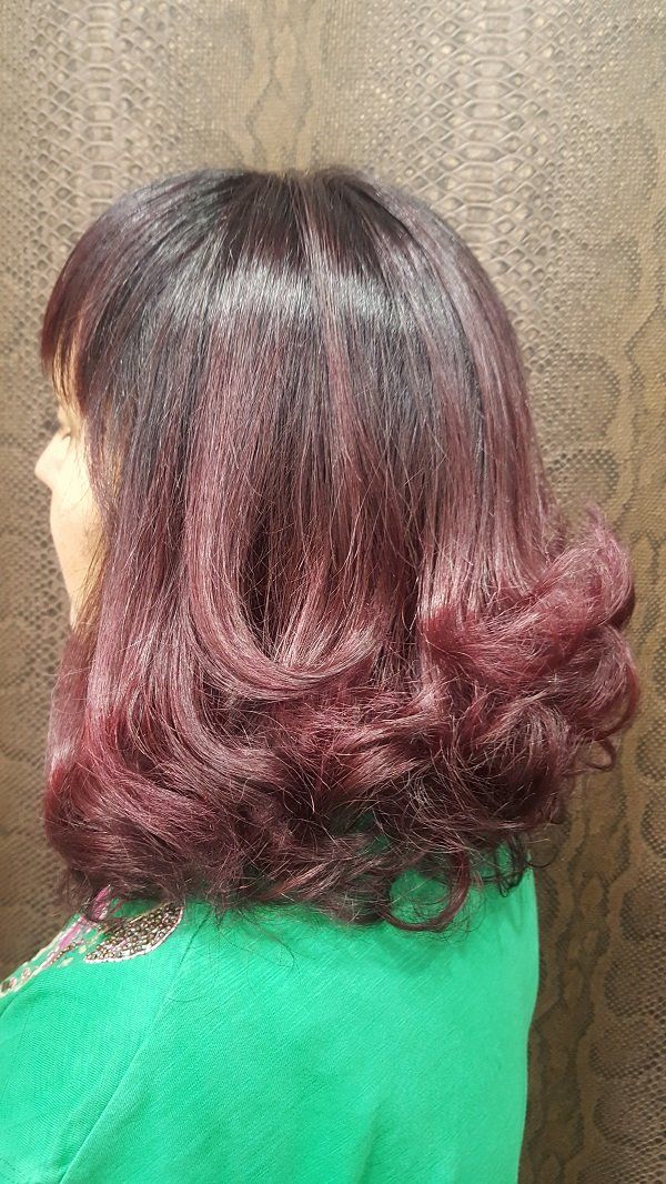 Una mujer con cabello rojo lleva una camisa verde.