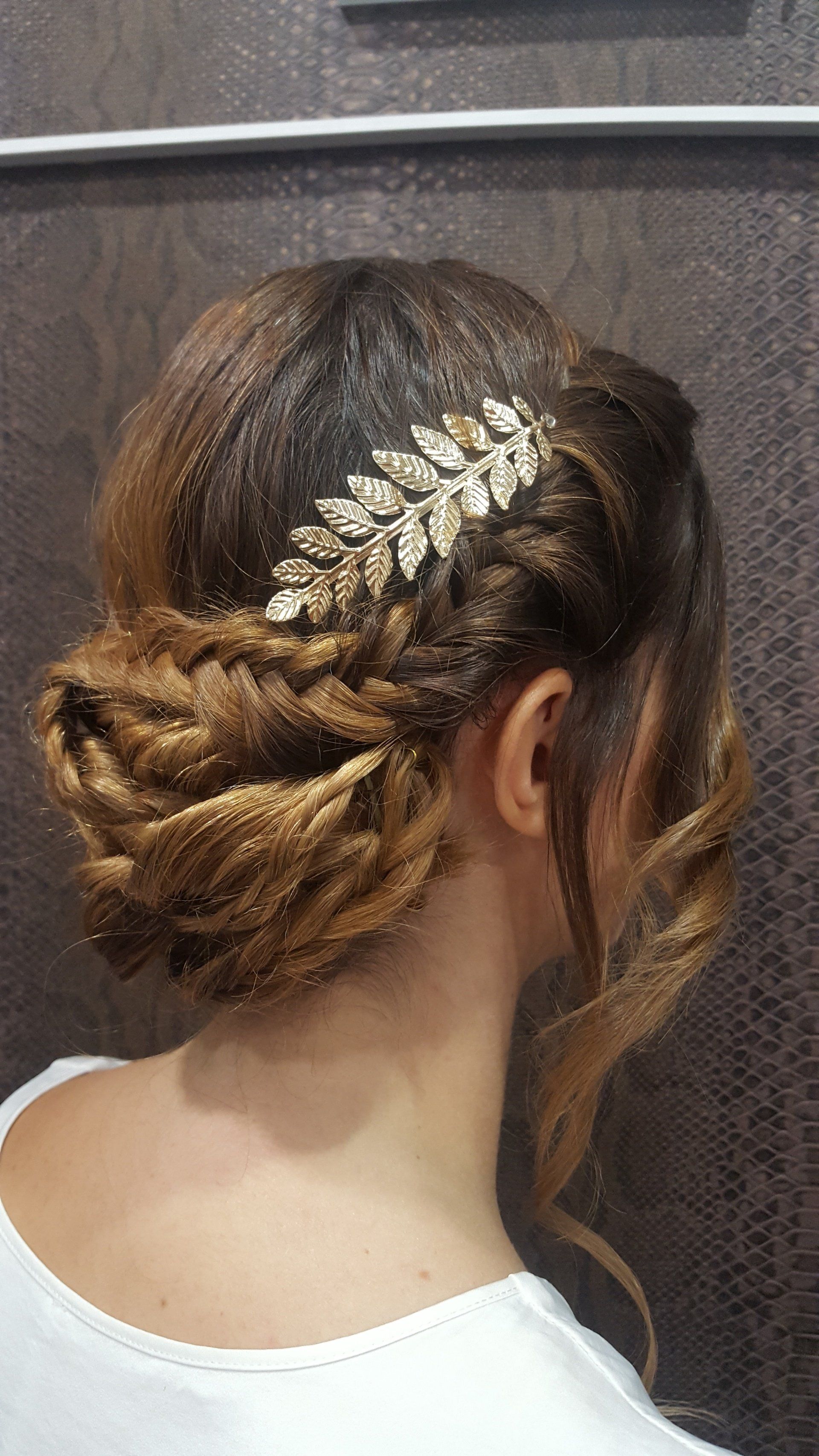 Una mujer lleva un moño trenzado con un tocado en el pelo.