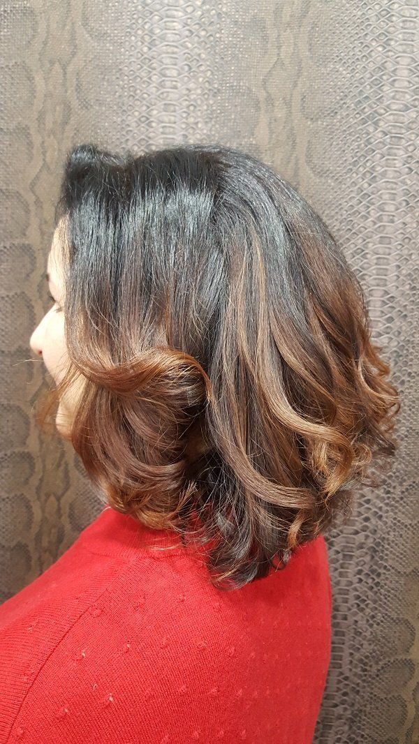 Una mujer con pelo corto está sentada en una silla roja.