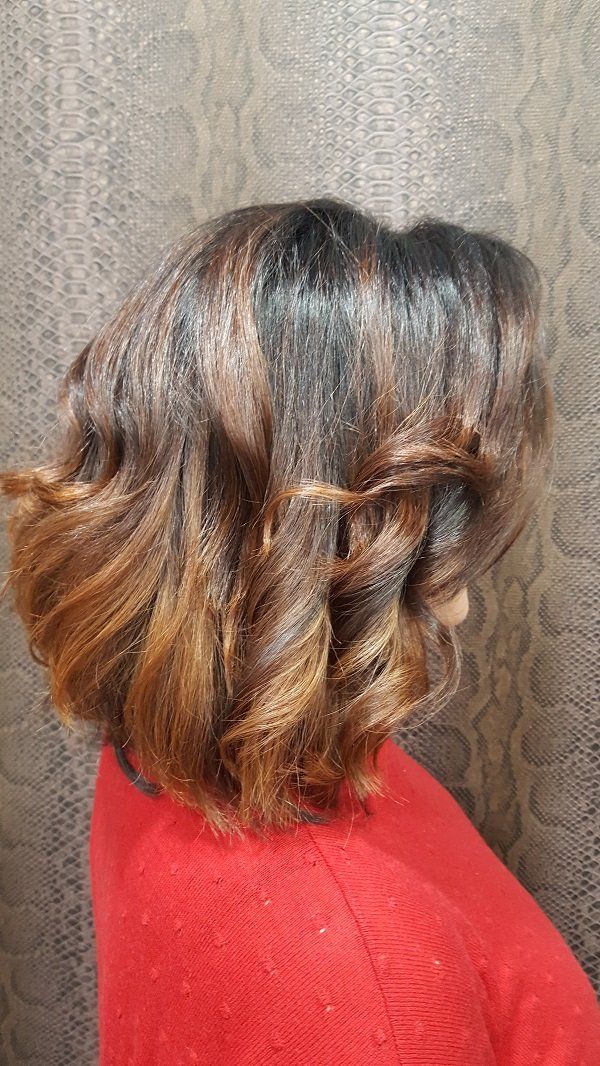 Una mujer con pelo corto lleva un suéter rojo.