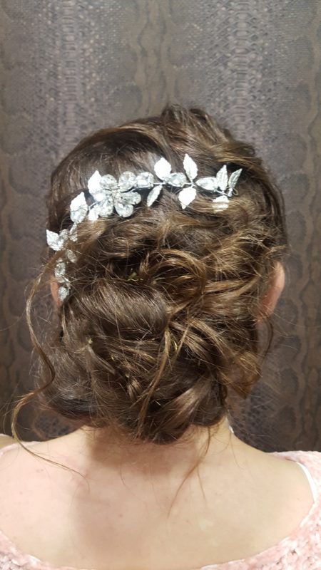 La espalda de una mujer que lleva un moño y un tocado.