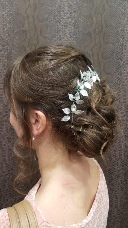 Una mujer lleva un moño con flores en el pelo.