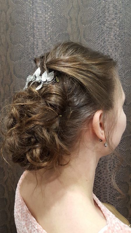 Una mujer lleva el pelo recogido en un moño con una flor en él.