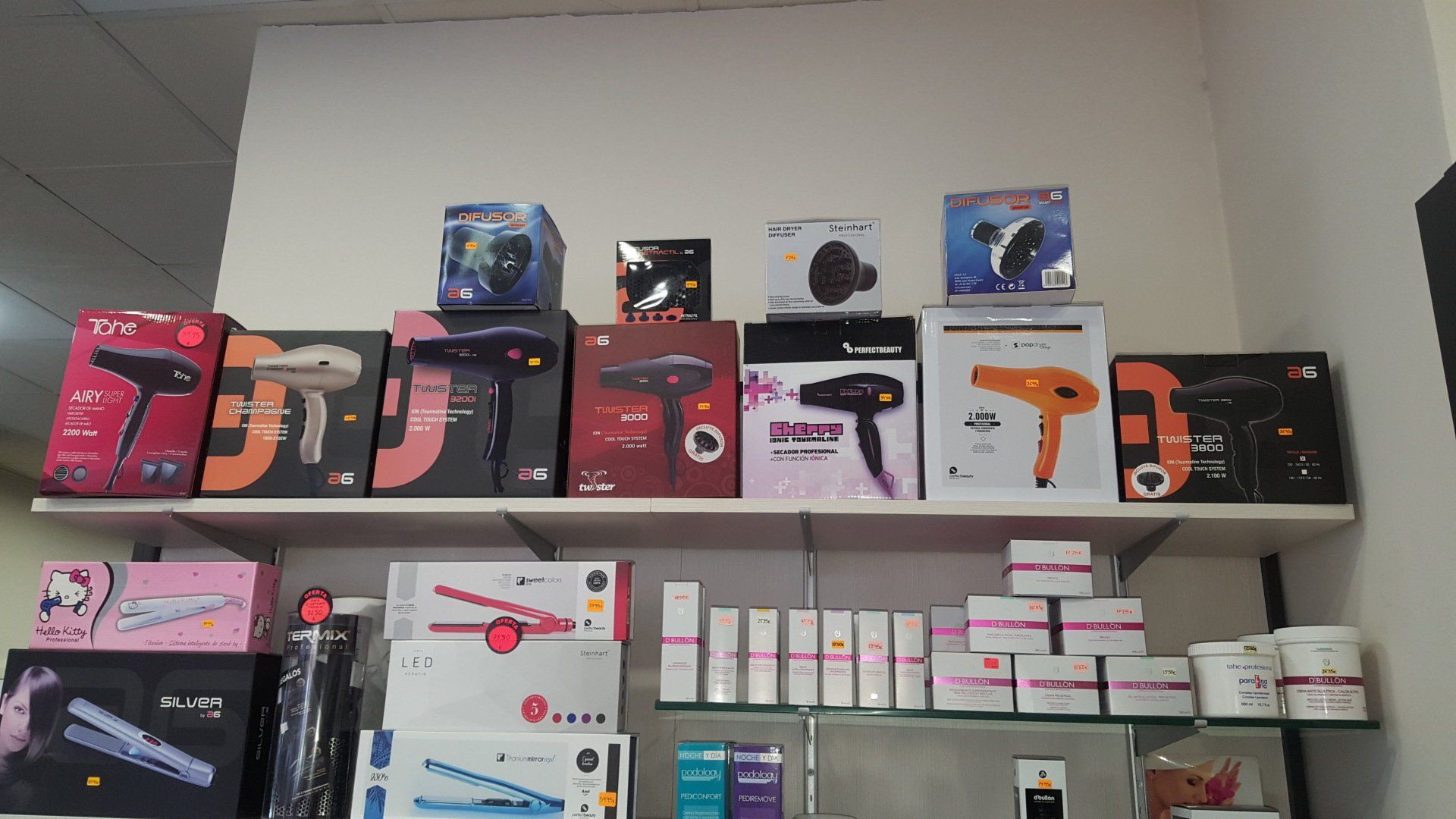 Un montón de secadores de pelo están en un estante de una tienda.