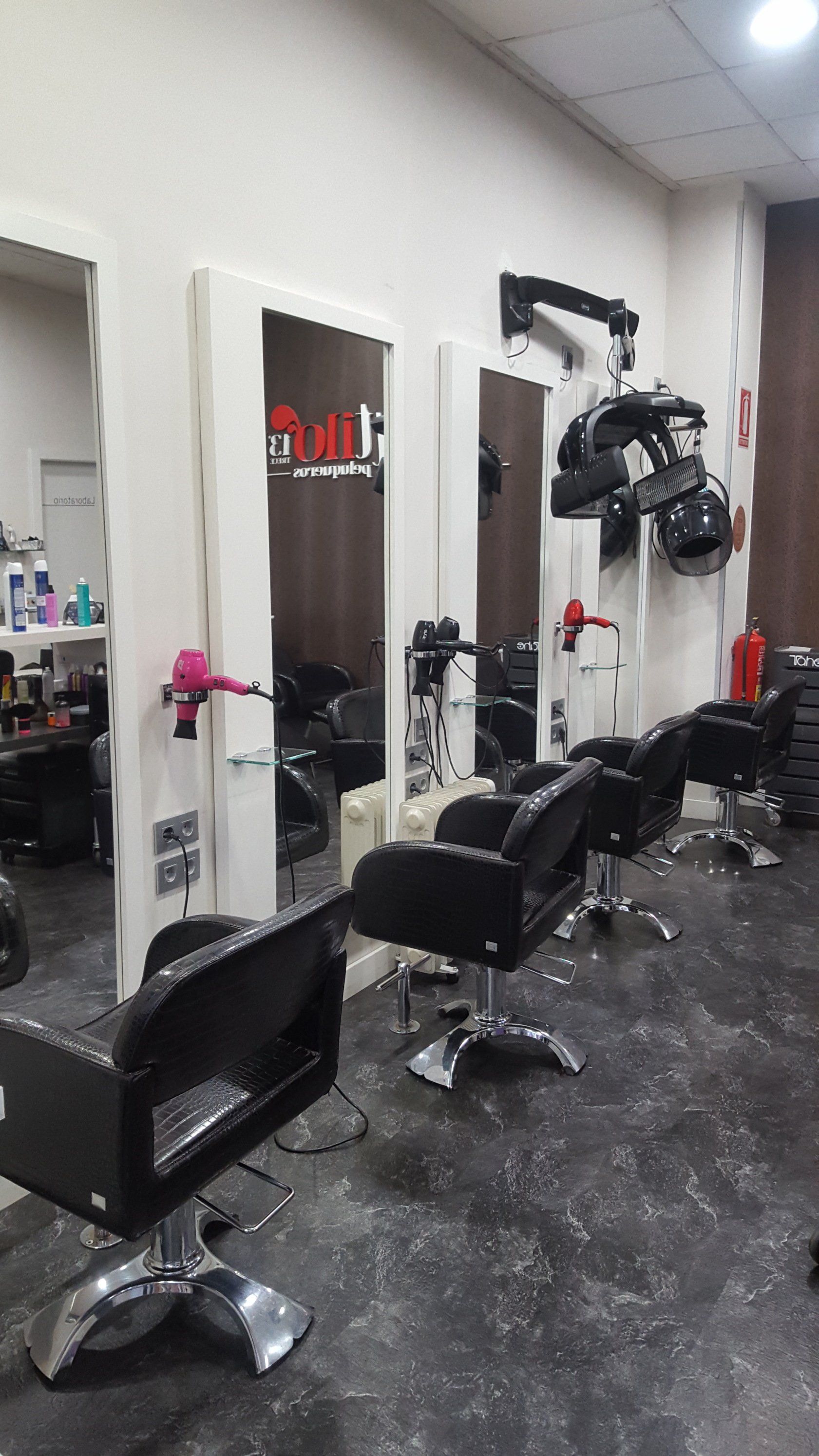 Una peluquería con muchas sillas y espejos.