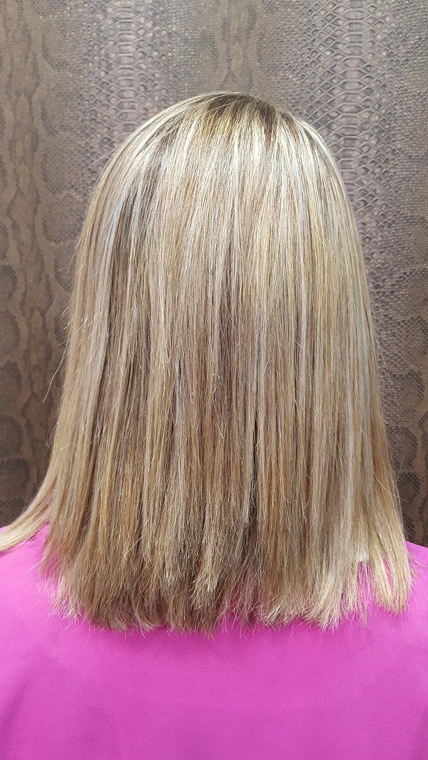 Se muestra la parte posterior del cabello rubio de una mujer.