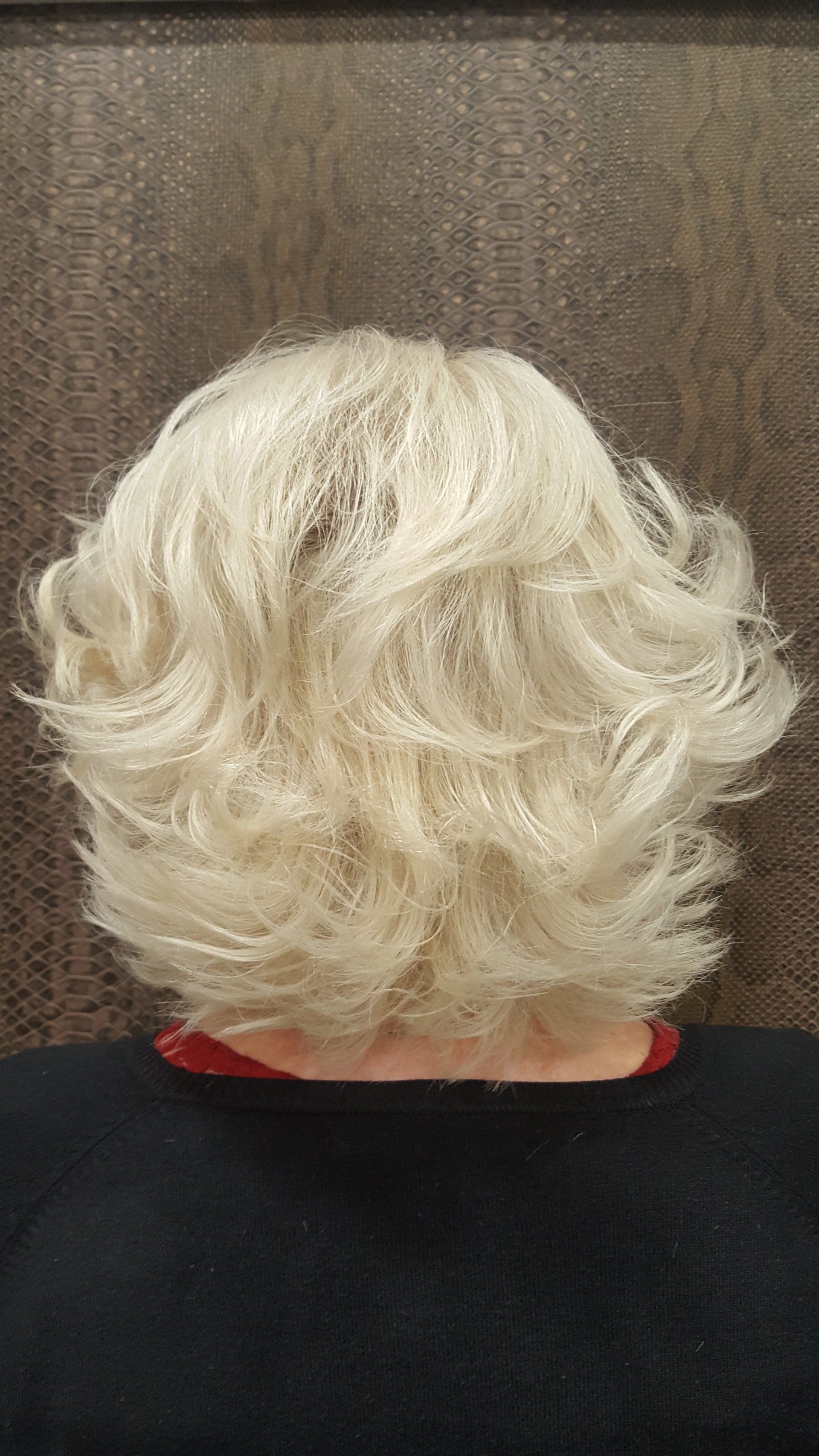 La espalda de una mujer con una peluca blanca.