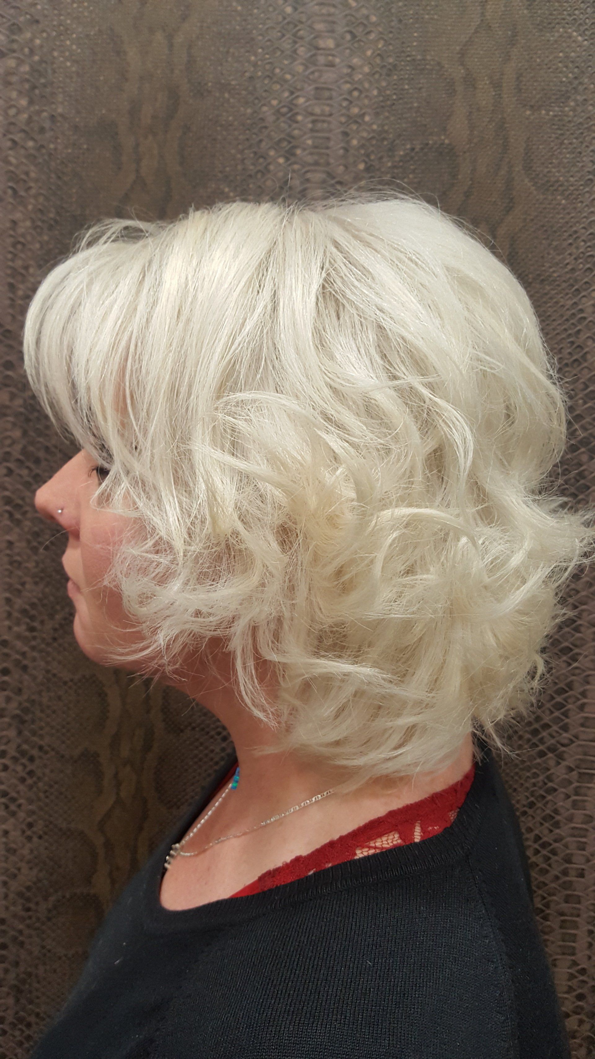 Una mujer con cabello rubio lleva un suéter negro y un sujetador rojo.