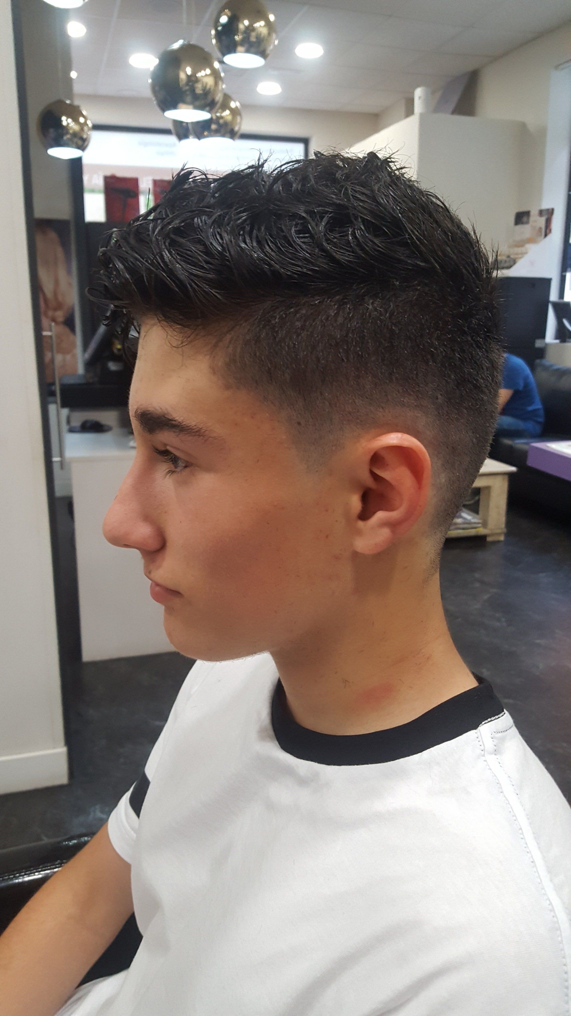 Un joven se está cortando el pelo en una peluquería.