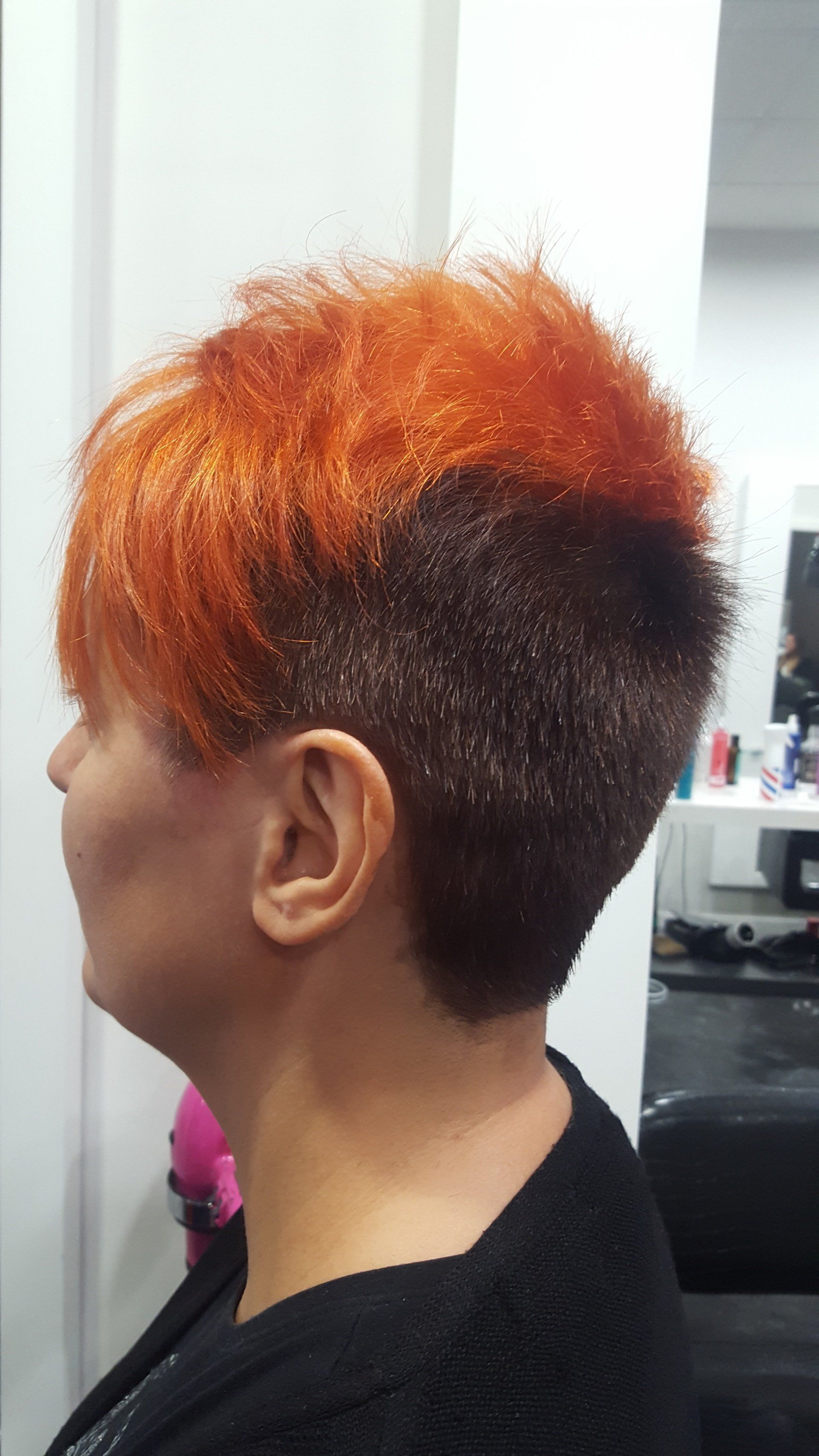 Una mujer pelirroja se está cortando el pelo en una peluquería.