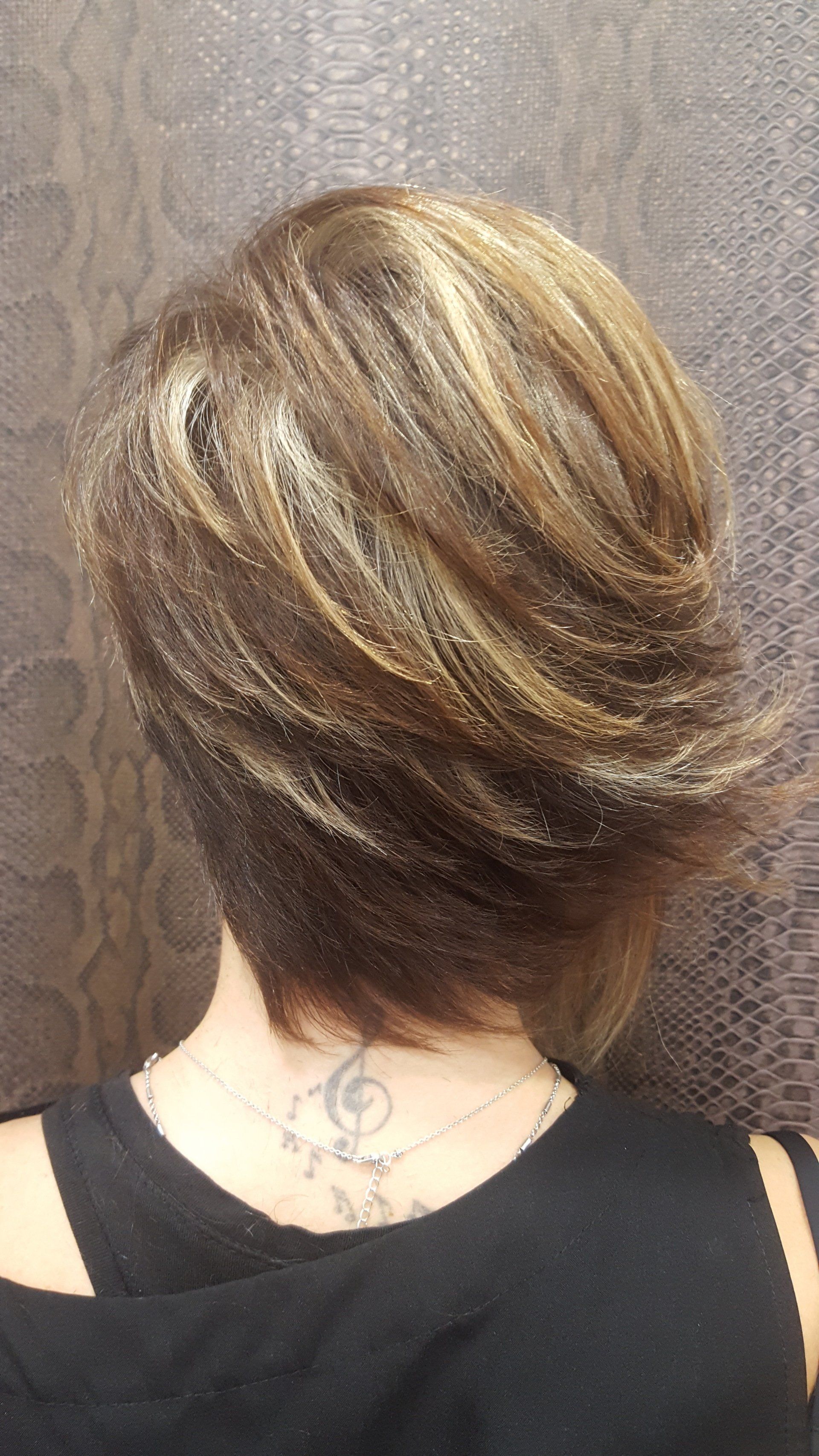 Una mujer con pelo corto y un tatuaje en la espalda.