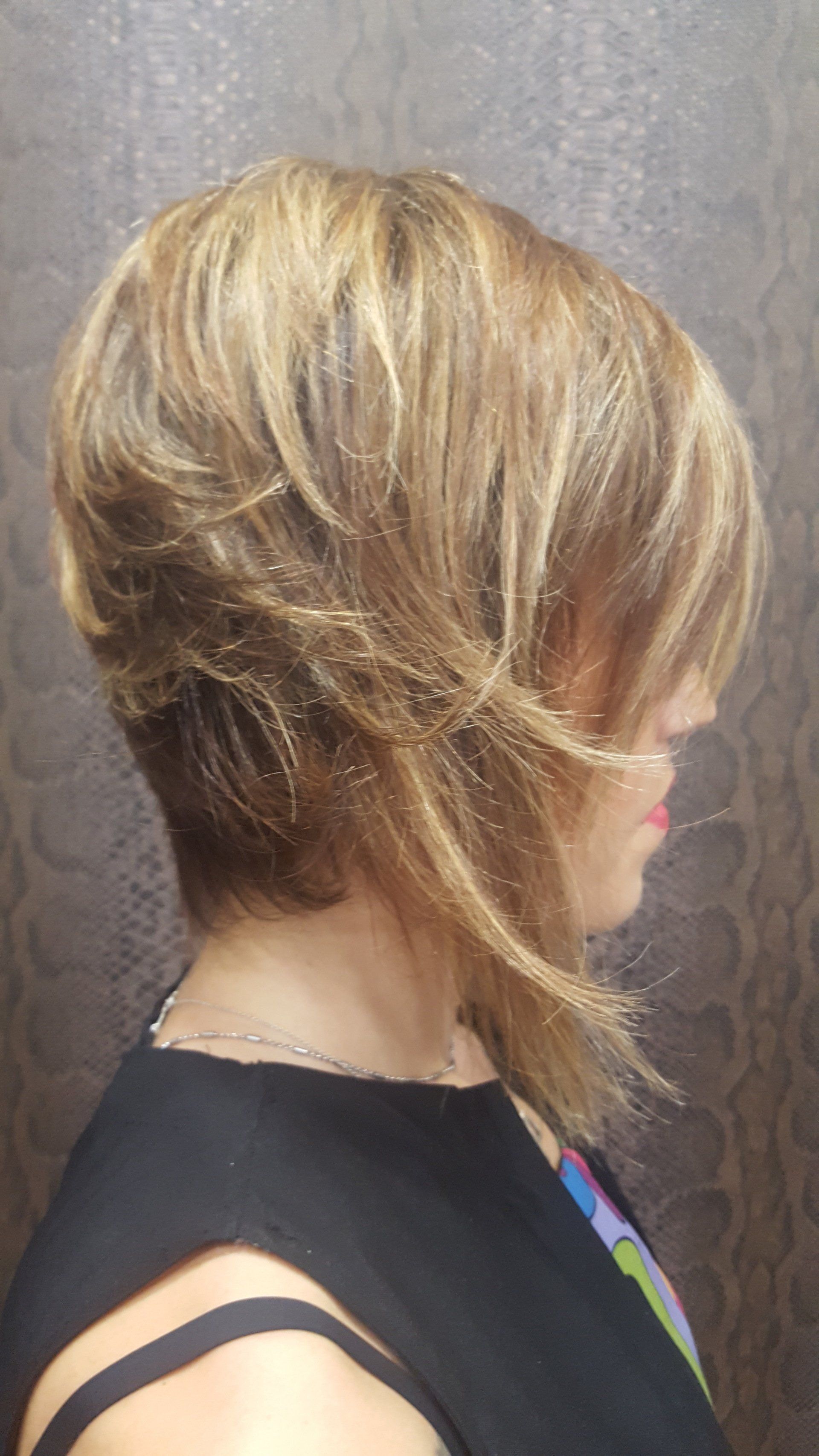 Una mujer con cabello rubio corto lleva un vestido negro.