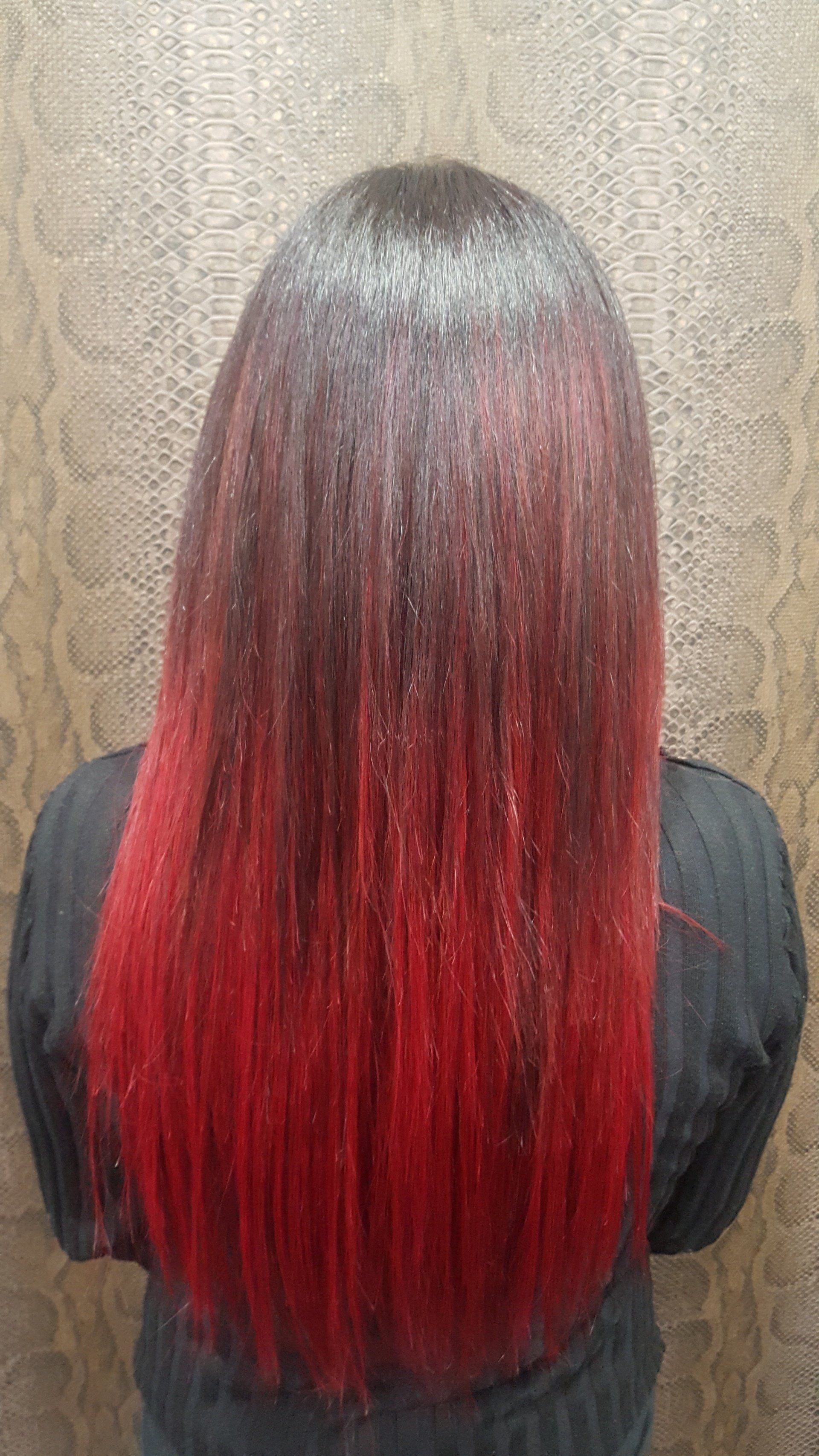 Una mujer con cabello rojo está parada frente a una pared.