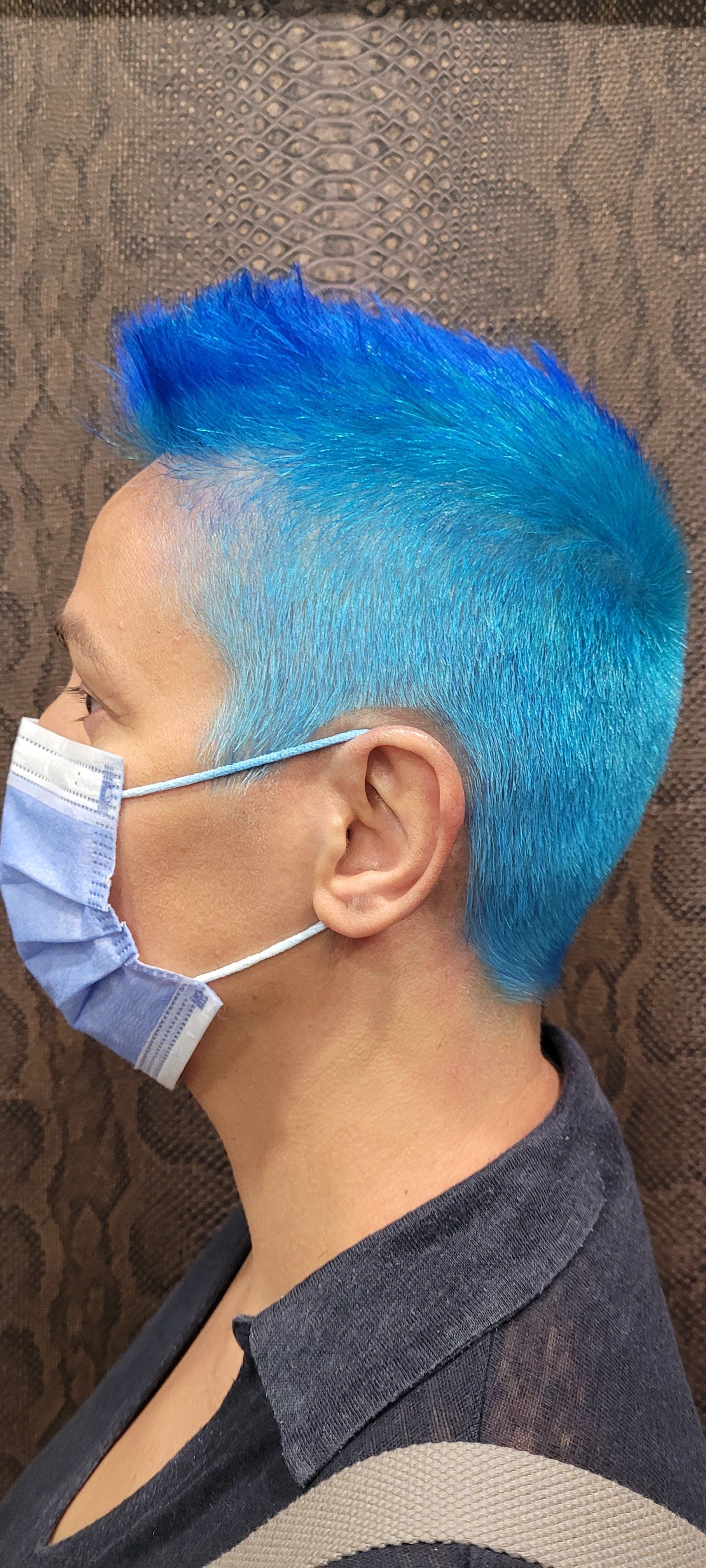 Una mujer con cabello azul y una máscara en la cara.
