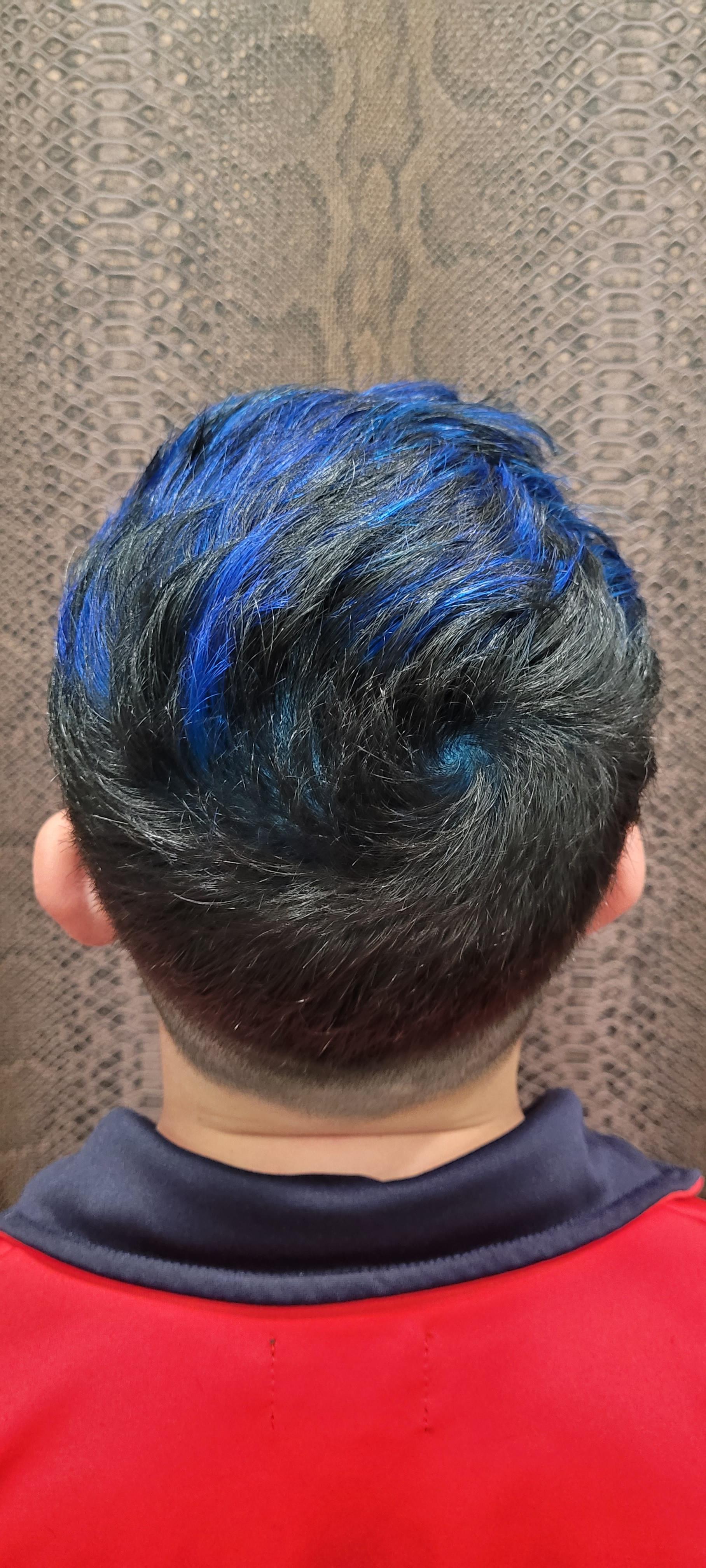 La parte posterior de la cabeza de una persona con cabello azul y una camisa roja.