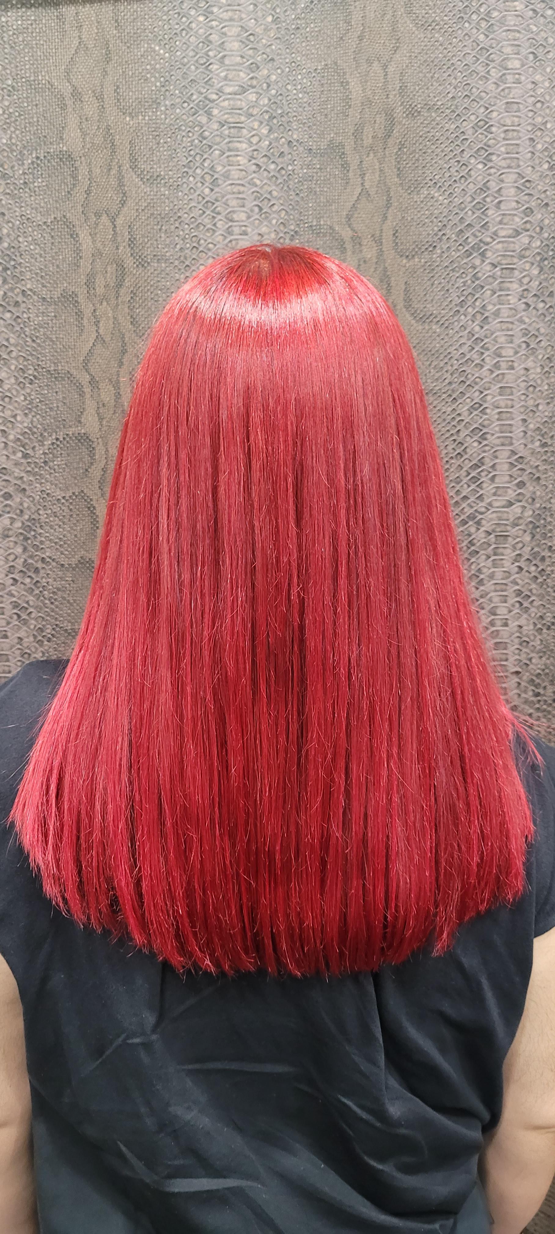 Una mujer con cabello rojo está sentada frente a una pared.