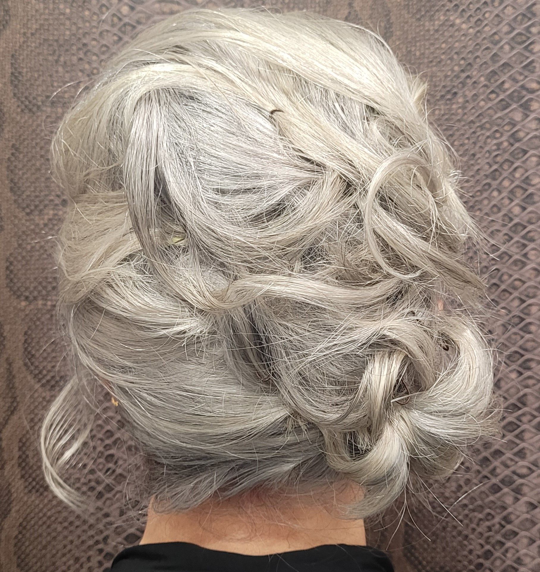 Una mujer con cabello gris lleva un moño.