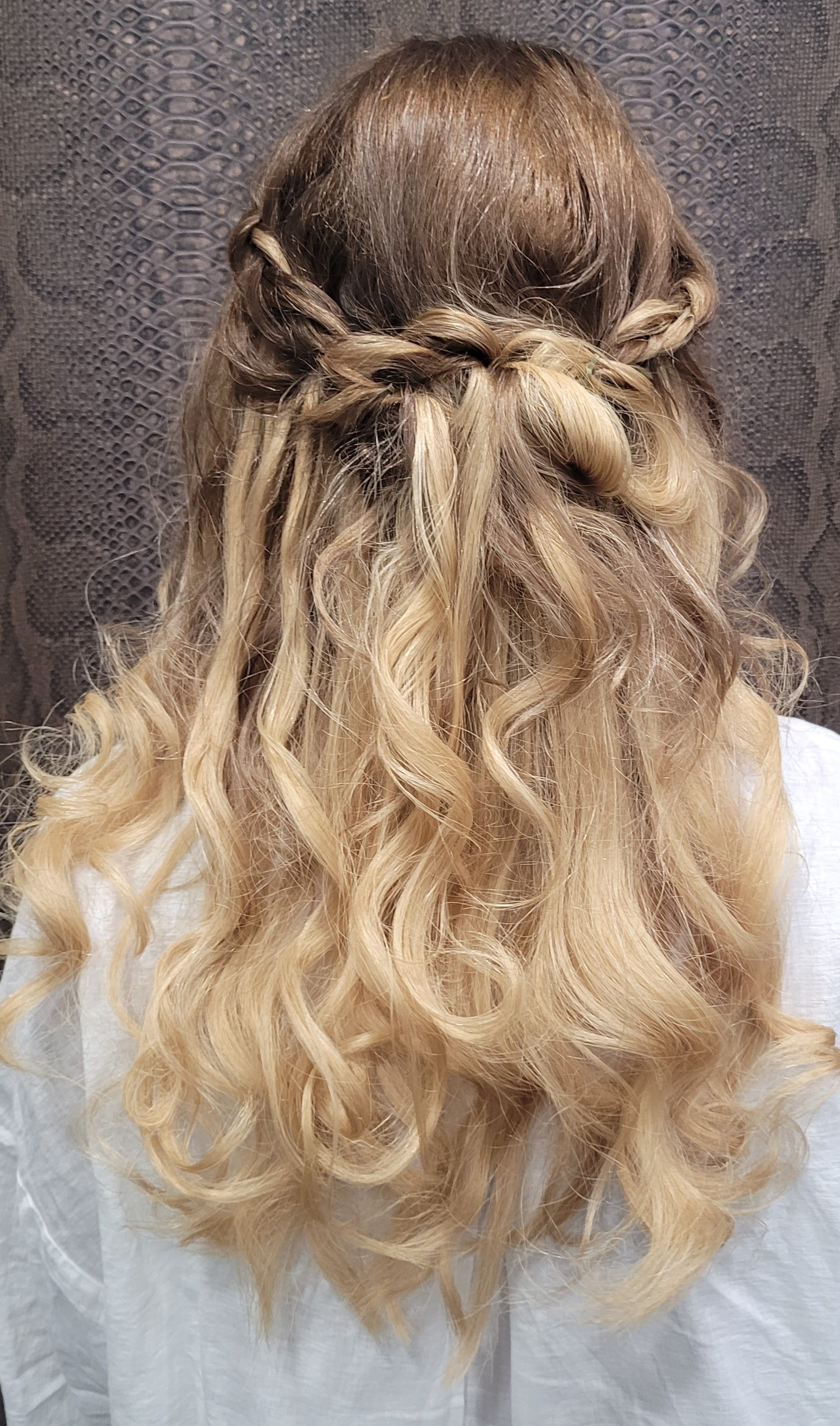 Una mujer con cabello rubio lleva un peinado mitad recogido mitad suelto.