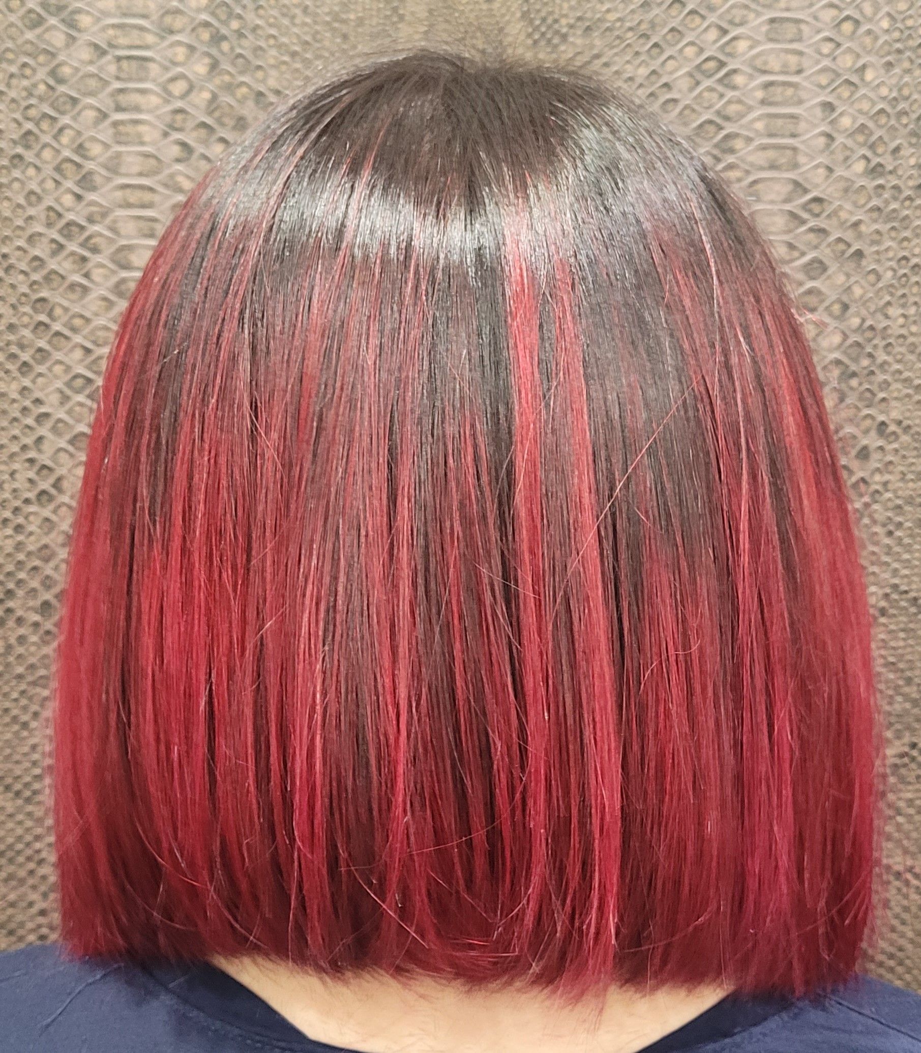 Una mujer con cabello rojo lleva una camisa azul.