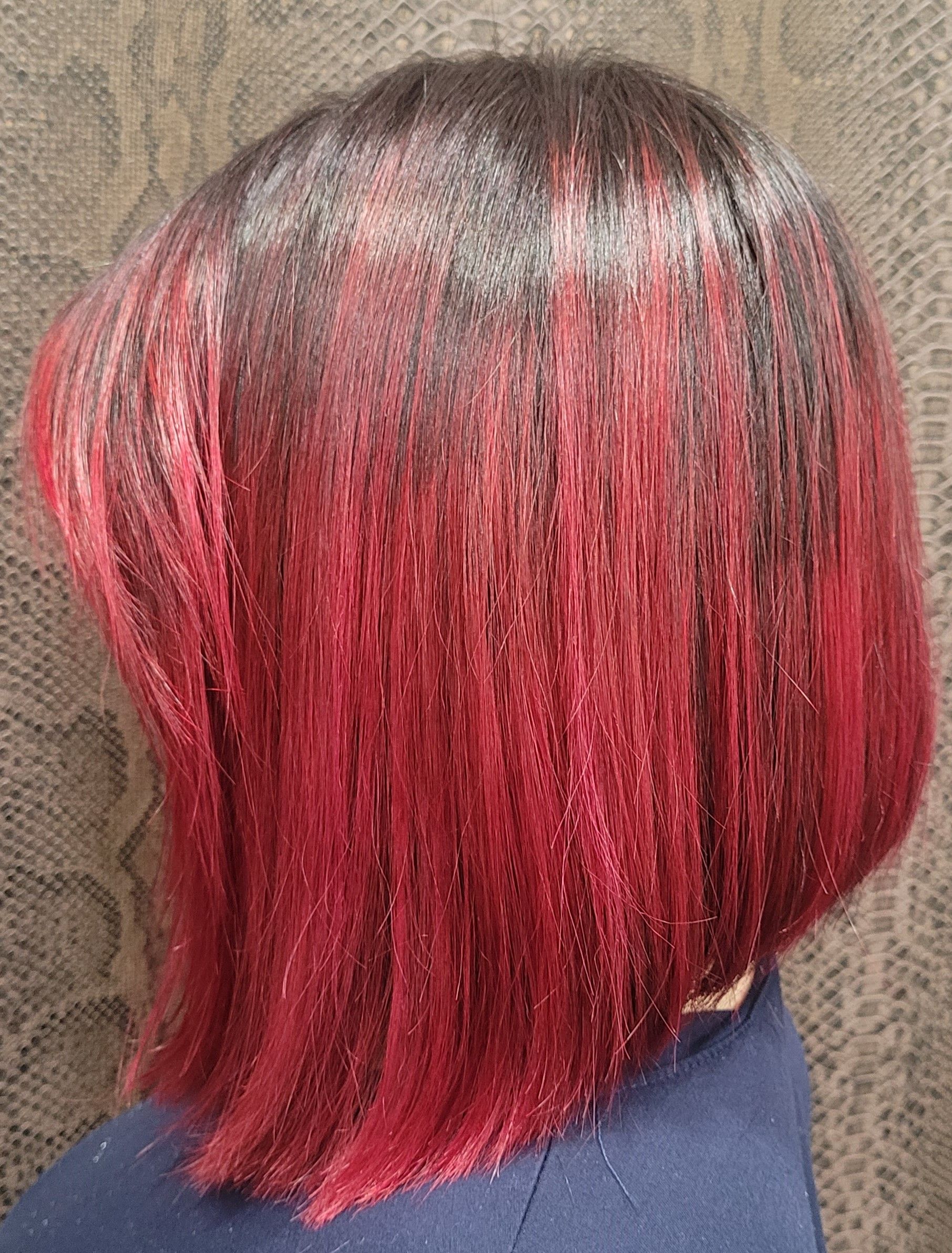 Una mujer con cabello rojo lleva una camisa azul.