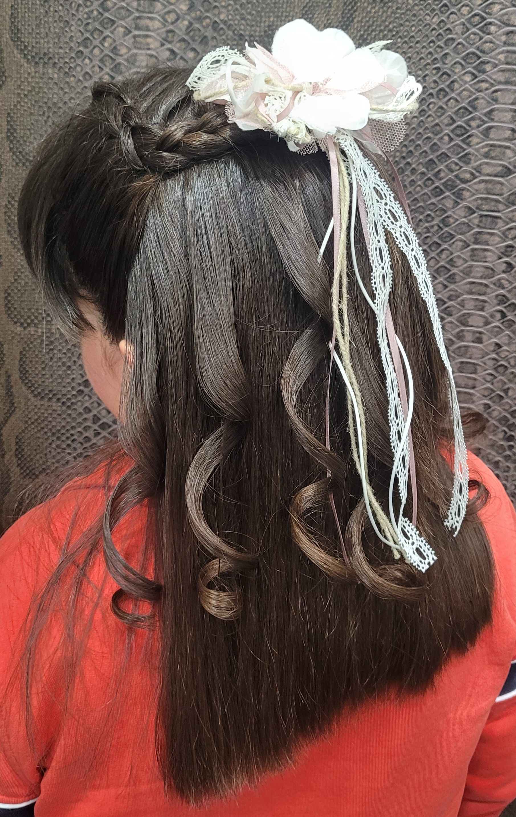 Una niña con pelo largo y una flor en el pelo.