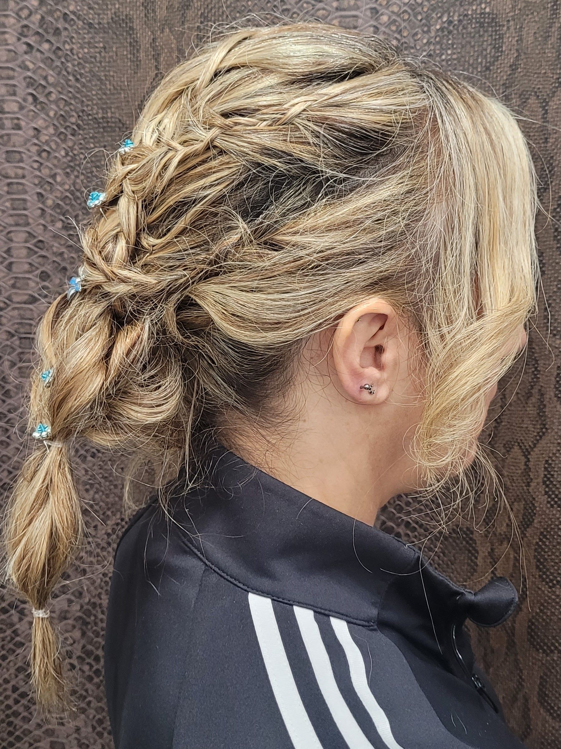 Una mujer con rastas rubias lleva una camiseta adidas negra.