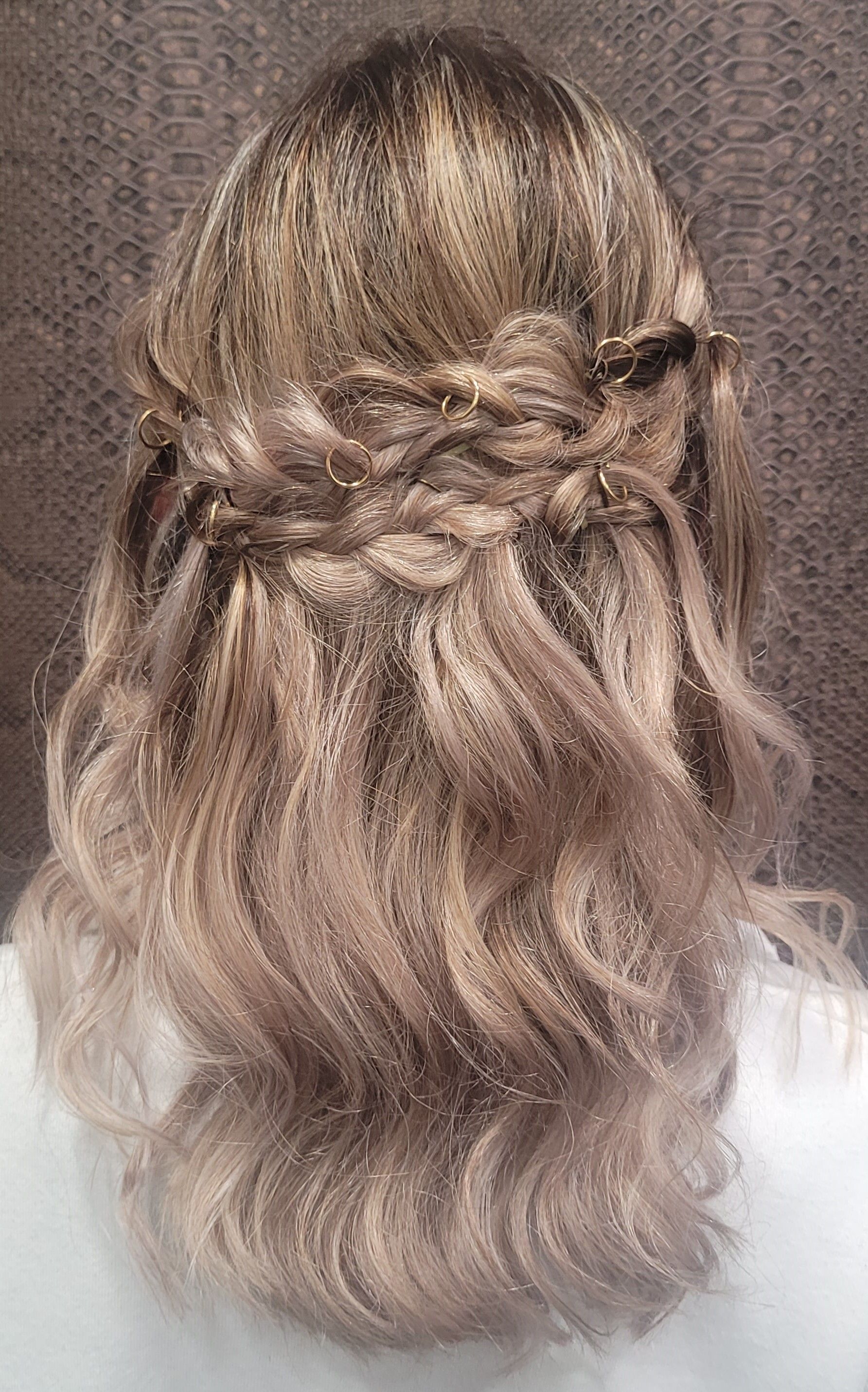 La parte posterior de la cabeza de una mujer con el cabello recogido mitad arriba y mitad abajo.