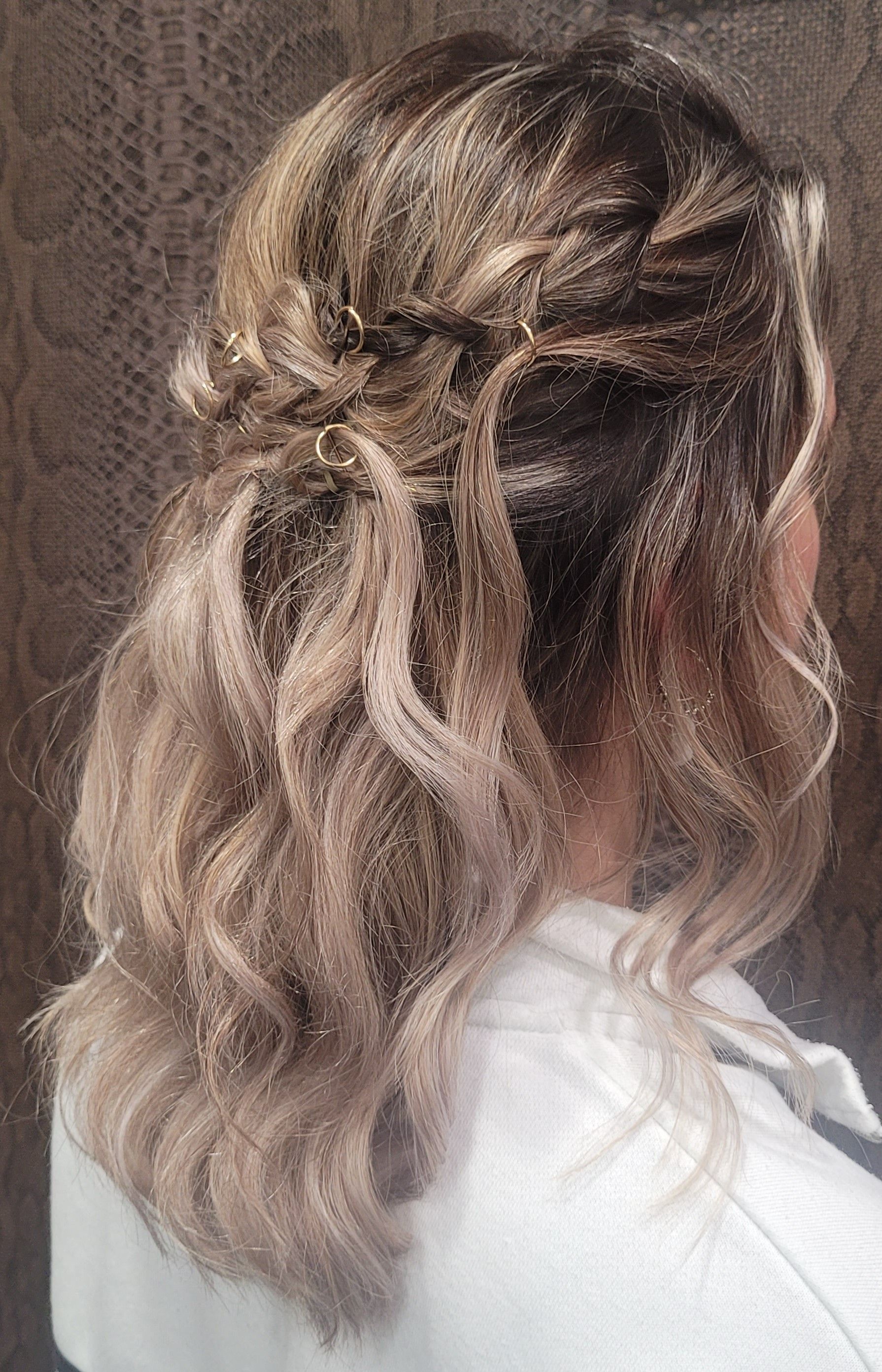 Una mujer con cabello rubio lleva un peinado mitad recogido mitad suelto.