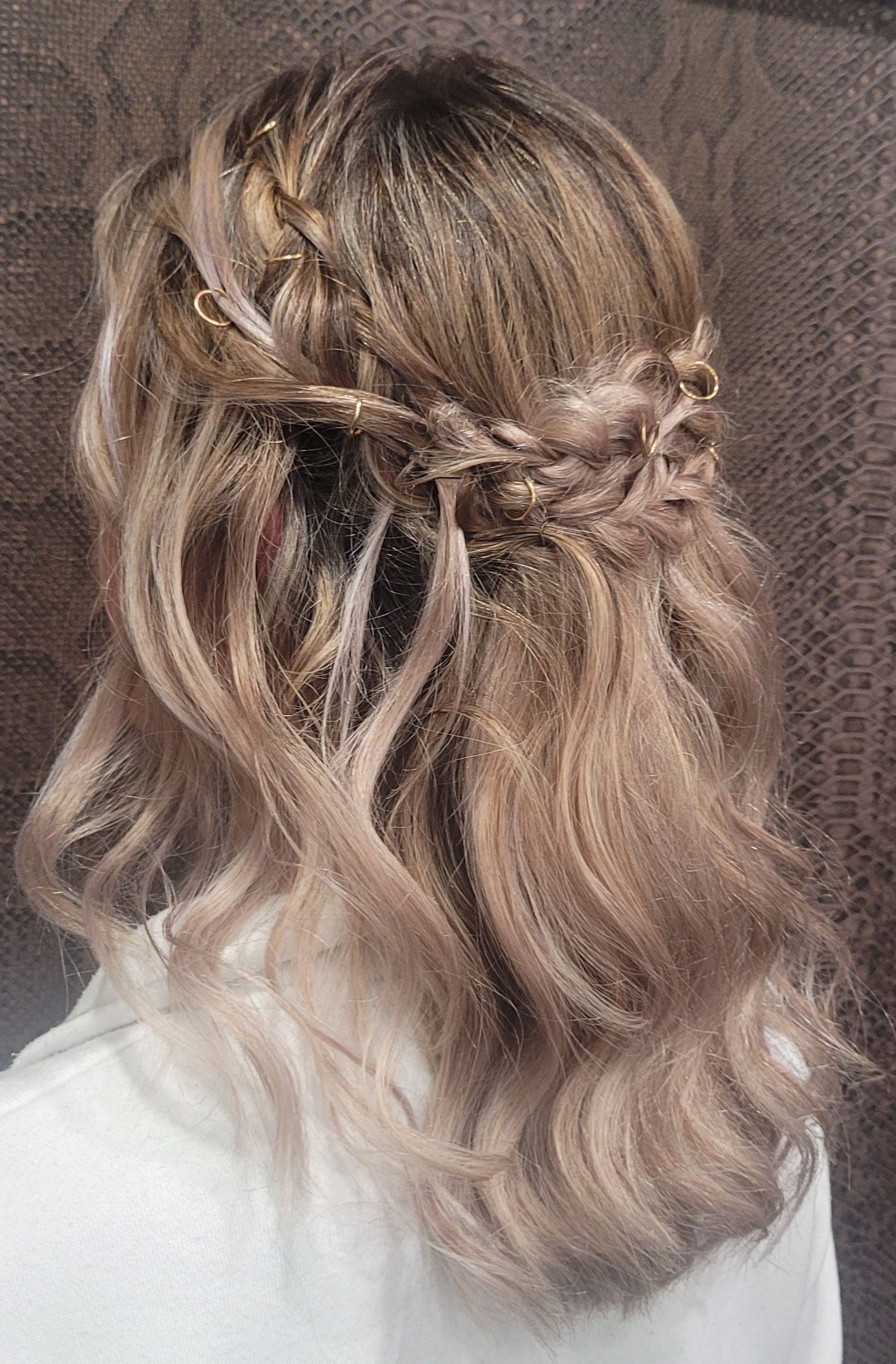 Una mujer con cabello rubio lleva un peinado mitad recogido mitad suelto.