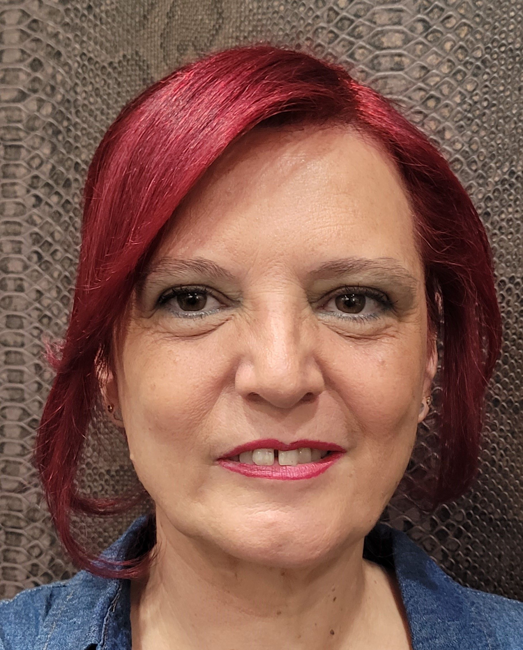 Una mujer con cabello rojo está sonriendo para la cámara.