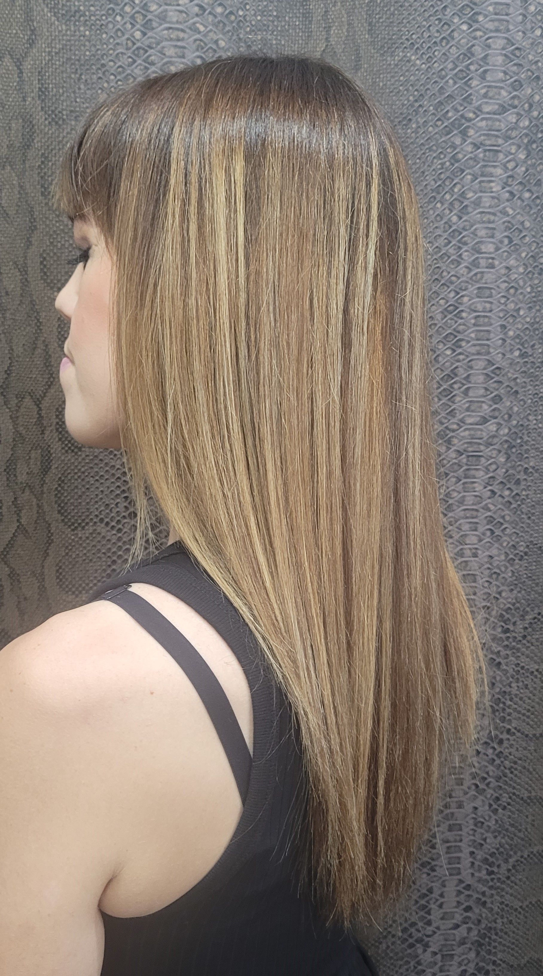 Una mujer con pelo largo lleva una camiseta negra sin mangas.