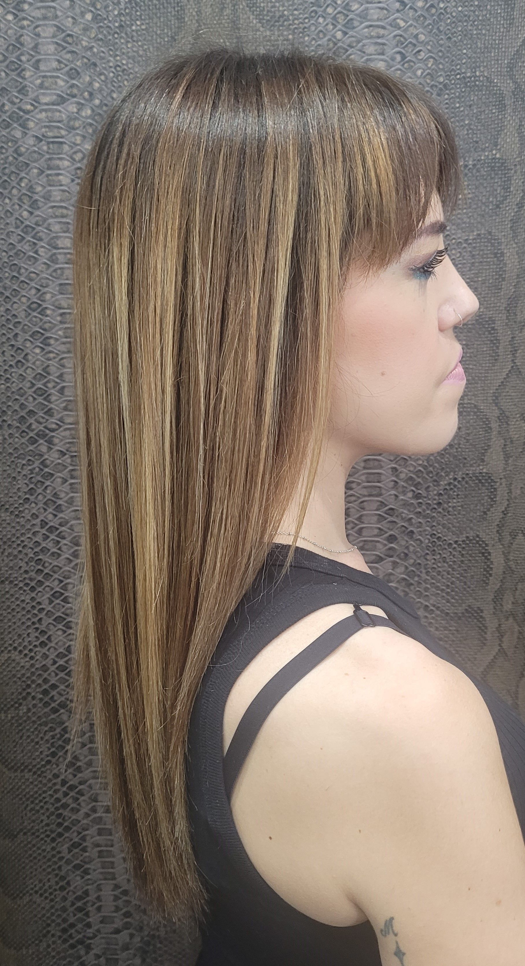 Una mujer con pelo largo lleva una camiseta negra sin mangas.