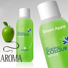 Una botella de esmalte de uñas de manzana verde junto a una manzana verde.